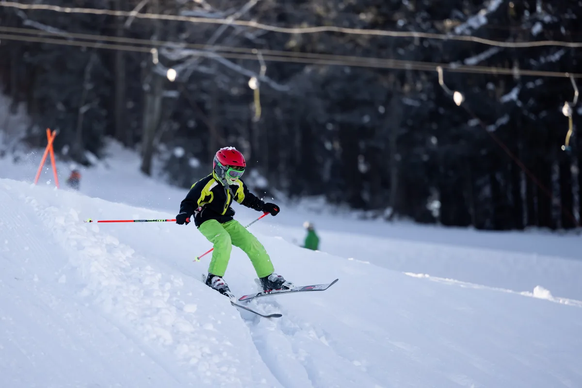 Ein skifahrendes Kind mit rotem Helm.